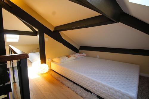 a bedroom with a white bed in a attic at HEART OF THE CITY 7 ! in Vila Nova de Gaia