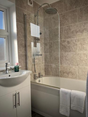 a bathroom with a tub and a sink and a shower at Three Bedroom City Home with Garden in Southampton
