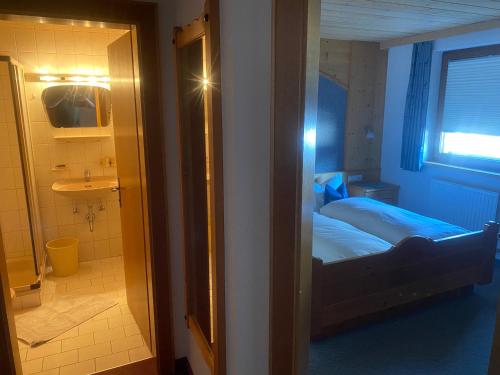 a bedroom with a bed and a bathroom with a window at Haus Schnöller in Bach