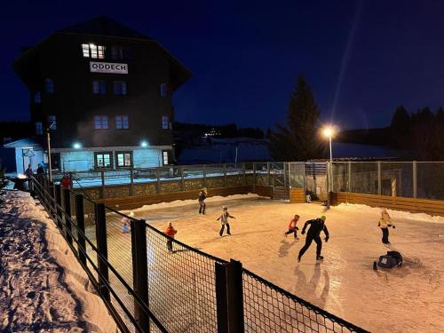 a group of people playing in the snow at night at Hotel Oddech in Pec pod Sněžkou