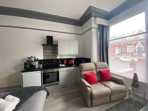 een woonkamer met een bank en een stoel en een keuken bij Blackpool Abode - 124 Elite Apartments in Blackpool
