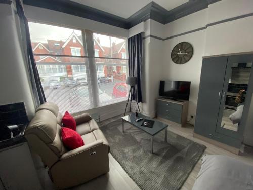 a living room with a couch and a large window at Blackpool Abode - 124 Elite Apartments in Blackpool