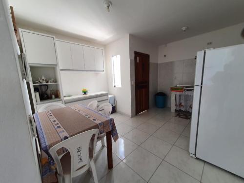 a kitchen with a table and a refrigerator at Casa Azul Gamboa do Morro in Gamboa