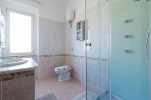 a bathroom with a shower and a toilet and a sink at The Orange House in Assemini