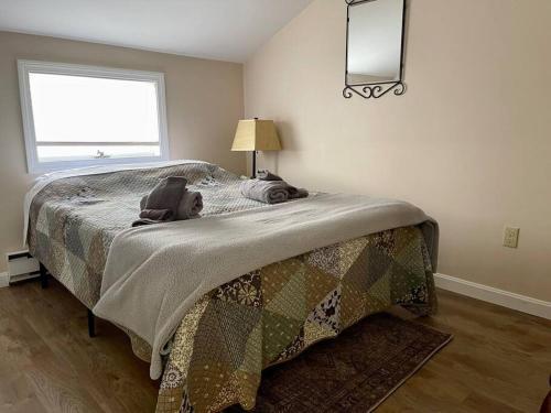 a bedroom with a bed with a blanket and a window at Oceanfront Penthouse with Family & Friends in Salisbury