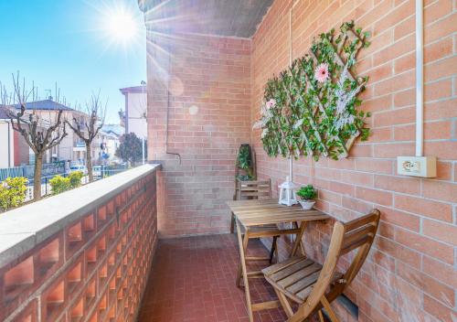 un patio con 2 sedie e un tavolo su un muro di mattoni di Garden house - con Terrazzo a Grugliasco