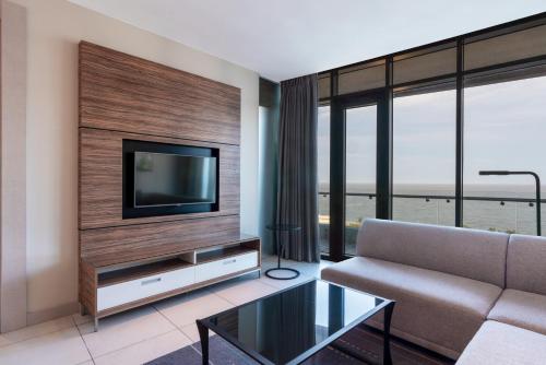 a living room with a couch and a television at Radisson Blu Hotel & Residence Maputo in Maputo