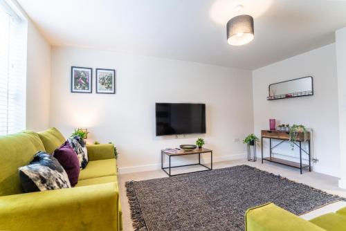 uma sala de estar com um sofá amarelo e uma televisão em Saltbox Stays - Modern 3 Bed with off-street parking for 2 cars, fast Wifi, sleeps 6 em Ashby de la Zouch