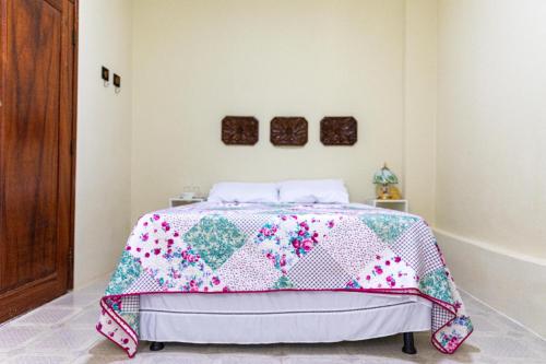1 dormitorio con 1 cama con edredón en Vila Barroca Estalagem, en São Cristóvão