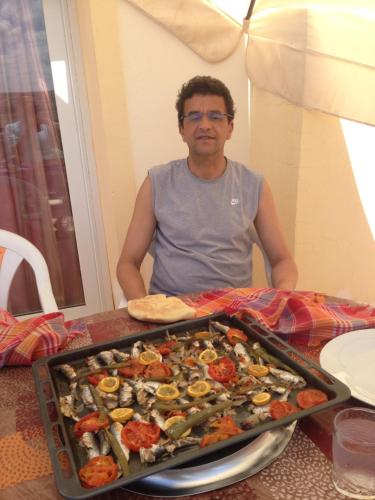 a man sitting at a table with a tray of food at Appartement El Bahia Saidia destiné uniquement aux couple mariés, célibataires s'abstenir in Saidia 