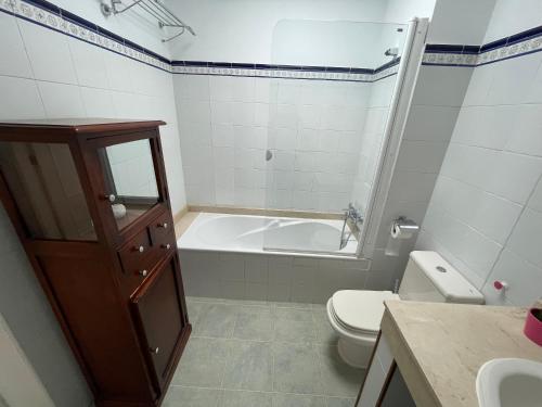 ein Badezimmer mit einer Badewanne, einem WC und einem Waschbecken in der Unterkunft Casa Brisa del Este in Mala