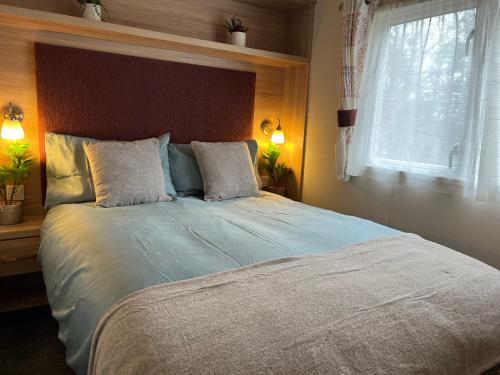 Un dormitorio con una cama grande con ventana. en forest beach bashley park, en Sway