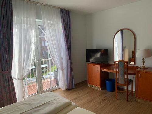 a bedroom with a bed and a desk and a window at Hotel Flora in Herzlake