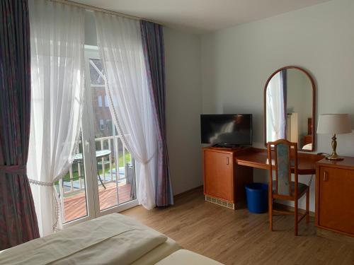 Schlafzimmer mit einem Bett, einem Schreibtisch und einem Fenster in der Unterkunft Hotel Flora in Herzlake