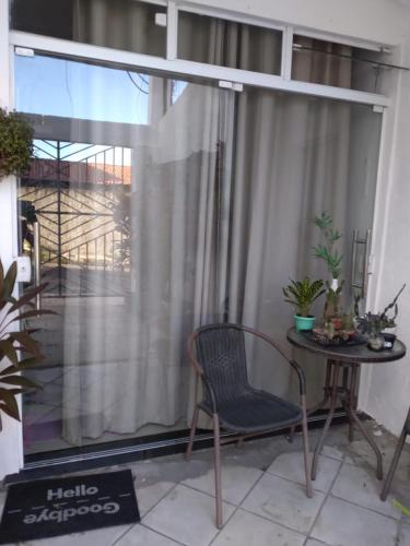 a chair and a table in front of a window at Casa Inteira aconchegante com garagem Próximo ao Aeroporto in Lauro de Freitas
