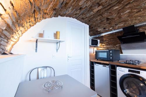- une cuisine avec lave-linge et sèche-linge dans la chambre dans l'établissement casa dei zitelli studio de charme avec jardin et terrasse, à Brando