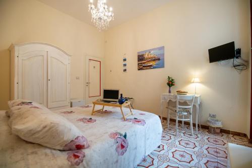 um quarto com uma cama e uma mesa com um computador portátil em Terre Dipinte em Salerno