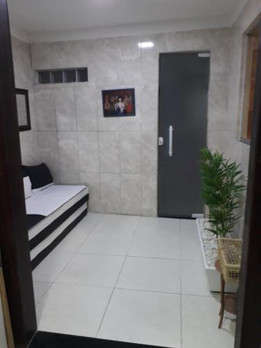 a room with a couch and a door with a plant at Casa Inteira aconchegante com garagem Próximo ao Aeroporto in Lauro de Freitas