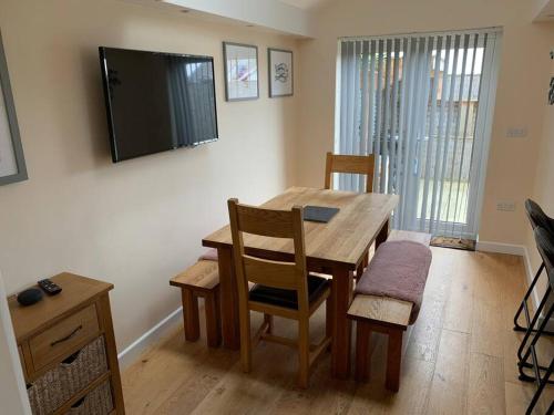 a dining room table with chairs and a television on the wall at 44 Raleigh Close@Padstow in Padstow
