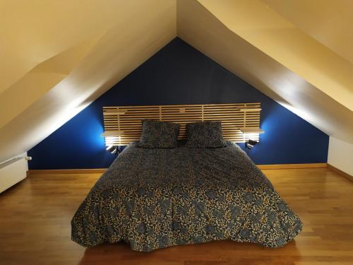 1 dormitorio con 1 cama con pared azul en La Manécanterie, en Bourges