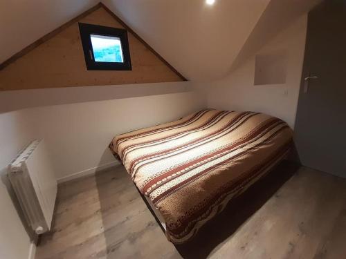 a small room with a bed in a attic at Gîte l'Eterlou - Chalet cosy avec jardin et vue sur Belledonne in Saint-Mury-Monteymond