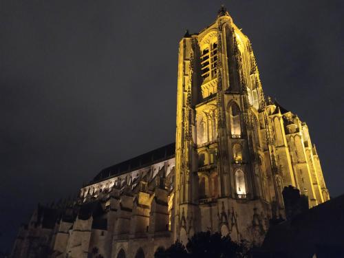 una torre de un edificio iluminado por la noche en La Manécanterie, en Bourges