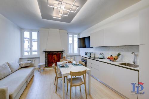 a kitchen and living room with a couch and a table at Apa Dom Downtown Family Apartment DesenzanoLoft Official Partner Homes & Villas by Marriott Bonvoy in Desenzano del Garda