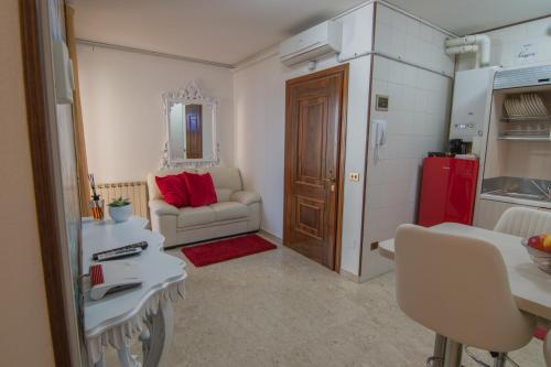 a living room with a couch and a red refrigerator at Maison Sophie in Chioggia