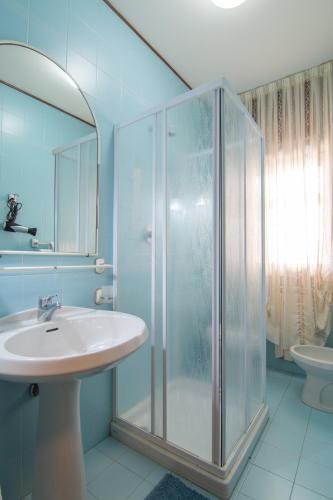 a bathroom with a glass shower and a sink at Maison Sophie in Chioggia