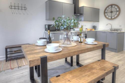 uma cozinha com uma mesa de madeira com flores em The Swell, Rhosneigr - Ground floor 2 bed With Parking em Rhosneigr