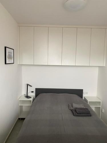 biały pokój z łóżkiem i białymi szafkami w obiekcie Apartament B122 z widokiem na morze w Gdańsku