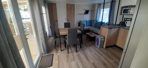 une chambre avec une table, une cuisine et une salle à manger dans l'établissement Mobil-home de charme dans les Landes, neuf, tout équipé, à Gastes