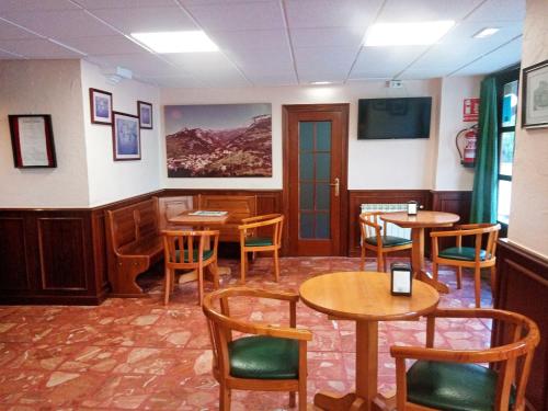 a restaurant with tables and chairs in a room at Hotel Rural Cabrales in Carreña de Cabrales 