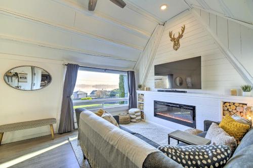 a living room with a couch and a fireplace at Puget Sound Cabin with Hot Tub and Water Views! in Bremerton