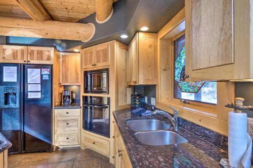 a kitchen with a sink and a refrigerator at Rustic Breckenridge Cabin with Hot Tub and Deck in Breckenridge