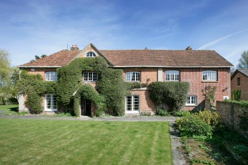 uma grande casa de tijolos com hera a crescer nela em Bridge Farmhouse em Salisbury