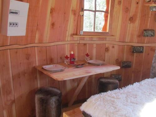 a small wooden table in a cabin with a window at Les Cabanes de Brassac in Brassac