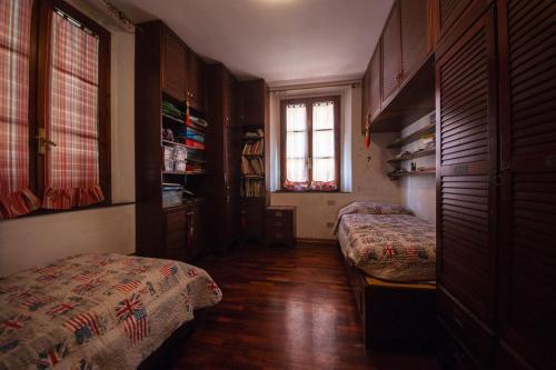 1 dormitorio con 2 camas y ventana en Grande appartamento in centro, en Pontedera