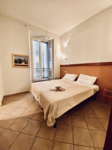 une chambre avec un lit et une grande fenêtre dans l'établissement Le Macé, à Cannes