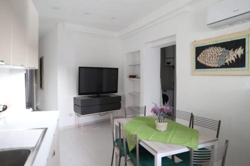 a dining room with a table and a tv at Casa Maadry in Ischia