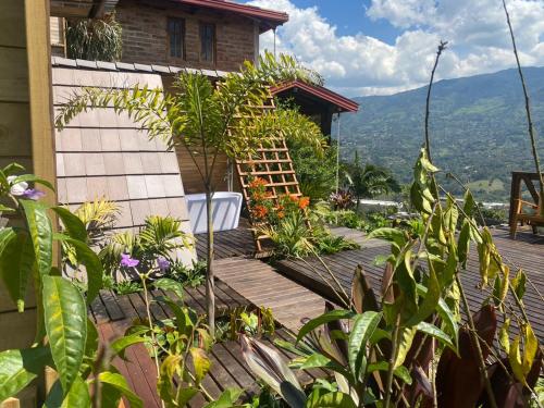 a house with a wooden staircase leading to a balcony at Finca Hotel Tierra Verde in Girardota