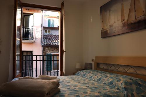 - une chambre avec un lit et un balcon dans l'établissement La Fata del lago, à Garde