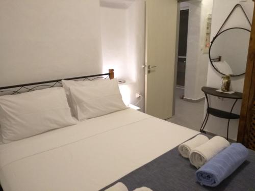 a bedroom with a bed with two towels and a mirror at Sea Breeze in Lachania