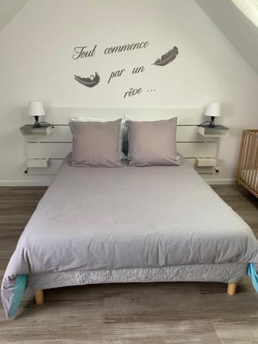 a bedroom with a bed with words on the wall at Logement calme et spacieux avec terrasses in Le Havre