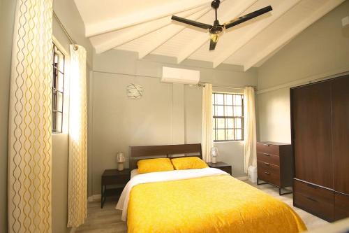 a bedroom with a yellow bed and a ceiling fan at Veronica's - Breathe Easy in Gros Islet