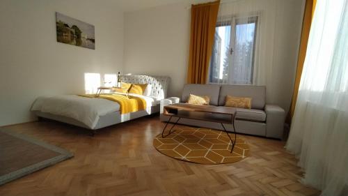 a bedroom with a bed and a couch and a chair at Vila Šik in Nové Město na Moravě
