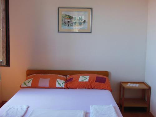 a bedroom with a bed with orange and white pillows at Apartments Paladina in Mandre