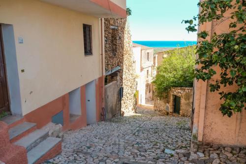 an alley in an old town with the ocean at Casa Angelina-Ammentos Posada in Posada