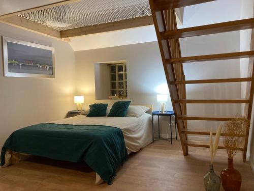 - une chambre dotée d'un lit avec des draps verts et une échelle dans l'établissement Le filet Cherbourgeois, à Cherbourg en Cotentin