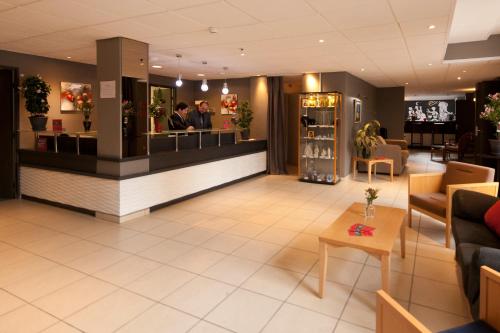 a lobby with a bar in the middle of a salon at Villa Mariale by Popinns in Lourdes